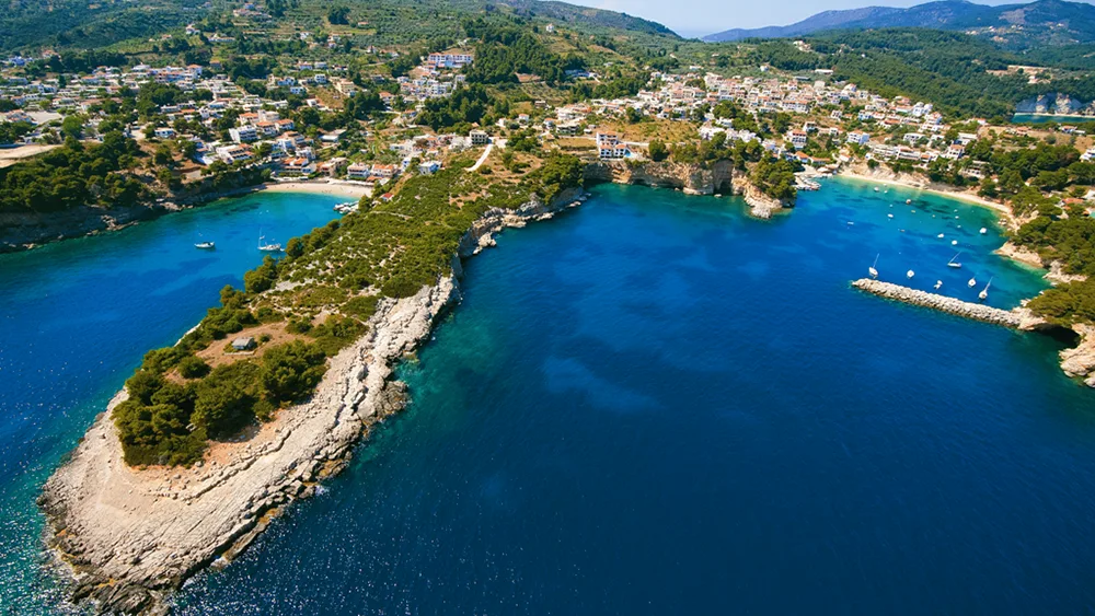 Aerial view of Alonissos Rousoum Gialos Bay near the port – turquoise waters and sailing yachts.