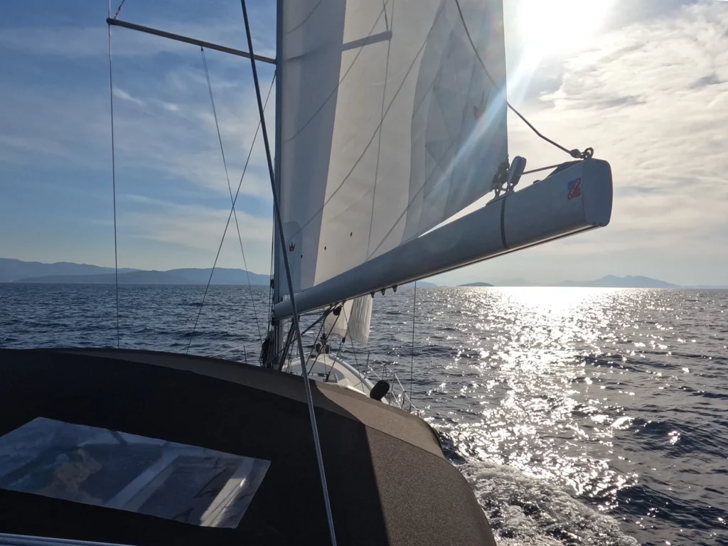 Sailing yacht Zoe under sail at sea with sunlit water and open horizon